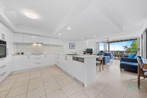 a kitchen with white cabinets and a living room at Cylinder Cove 9 in Point Lookout