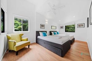 two beds and a chair in a room with white walls at Cylinder Cove 9 in Point Lookout