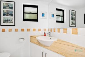 a bathroom with a sink and some pictures on the wall at Cylinder Cove 9 in Point Lookout +9 photos
