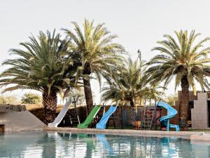 a pool with palm trees and slides in a resort at Victory Towers in Bloemhof