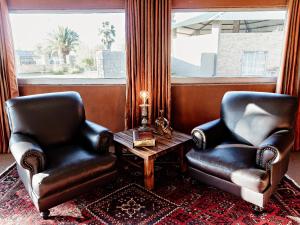 two chairs and a table in a room with a window at Victory Towers in Bloemhof +25 photos