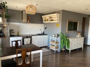 eine Küche mit weißen Schränken und einem Tisch darin in der Unterkunft OM West in Aizpute