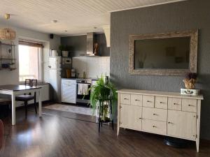 eine Küche mit einem Tisch und einem weißen Kühlschrank in der Unterkunft OM West in Aizpute