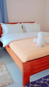 two beds with white sheets and pillows at The Elite havens in Nairobi