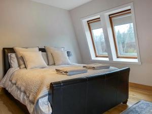 a large bed in a room with two windows at The Annexe - Uk51362 in Dollar