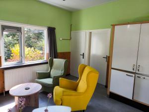 a living room with two chairs and a table at Vakantiepark de Bronzen Eik in Sellingen