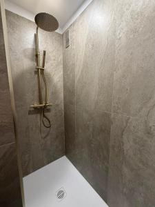 a bathroom with a shower with a stone wall at AVENUE DE CHAMPAGNE in Épernay +15 photos