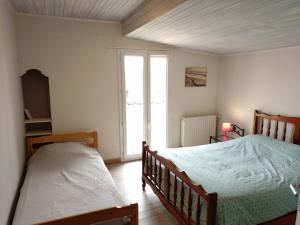 a bedroom with a bed and a large window at La Maison de l'Ormeau in Montauban