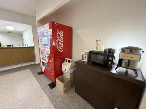 a coca cola machine in an office with a microwave at Hotel Tetora HonHachinohe in Hachinohe