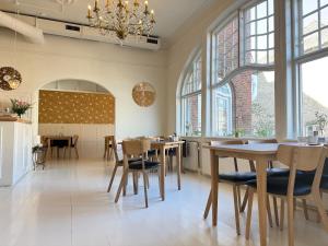 a dining room with tables and chairs and windows at Hotel Faaborg in Faaborg