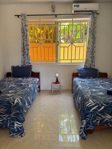 two beds in a room with stained glass windows at Rainbow Palace Apartment in Sekondi-Takoradi