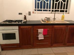 a kitchen with a sink and a stove top oven at Rainbow Palace Apartment in Sekondi-Takoradi +13 photos