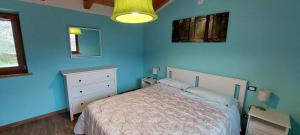 a bedroom with a bed and a blue wall at B&B Happy Guest in Caprino Veronese