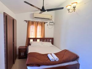 a bedroom with a bed with a ceiling fan at Rainbow721 in Pondicherry