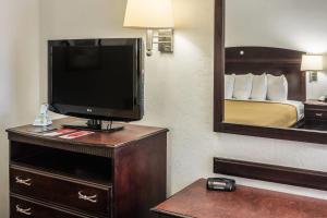 a hotel room with a television and a bed at Econo Lodge Palm Coast Central in Palm Coast