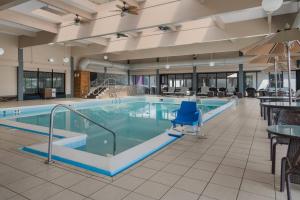 a pool in a hotel with chairs and tables at Radisson Hotel Grand Rapids Riverfront in Grand Rapids