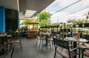 ein Restaurant mit Tischen und Stühlen auf einer Terrasse in der Unterkunft Hotel 88 Embong Malang Surabaya By WH in Surabaya