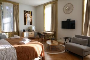 a hotel room with a bed and a chair and a tv at Hôtel Séquoias in Ruy