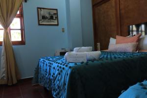 a bedroom with a bed with a blue comforter at Hacienda Casa de Piedra in Tlacolula de Matamoros