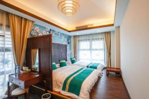 a bedroom with a bed and a desk and a window at Book and Bed-ChongMing in Shanghai