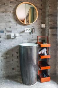 a bathroom with a round mirror and a metal trash can at Book and Bed-ChongMing in Shanghai +14 photos