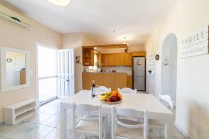 a kitchen and dining room with a white table and chairs at Pounda Breeze in Pounda