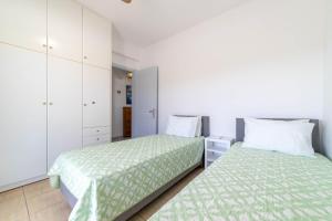 a bedroom with two beds and white cabinets at Pounda Breeze in Pounda +27 photos