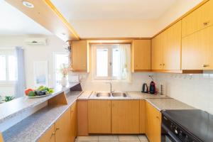 a kitchen with wooden cabinets and a sink at Pounda Breeze in Pounda