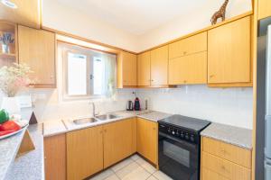 a kitchen with wooden cabinets and a sink at Pounda Breeze in Pounda