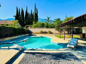 a swimming pool with a chair in a yard at Joshie home in Rancho Cucamonga