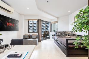 a living room with a bed and a desk at Studio for 5 at Tambuli Residences Garden View by Dominik Studio Apartment with Pool Access & Balcony in Mactan in Maribago