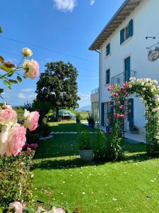 a garden with roses and an arch in front of a house at ROSETO HOLIDAYS AZZURRO in Cavalcaselle