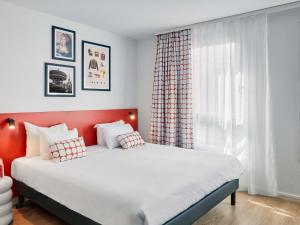 a bedroom with a large bed and a window at Aparthotel Adagio Access Paris Vanves - Porte de Versailles in Vanves