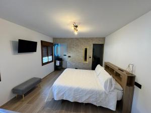 a bedroom with a bed and a tv on the wall at Verde in Alcalá del Júcar