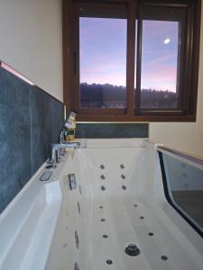 a bathroom with a bath tub with a window at Verde in Alcalá del Júcar