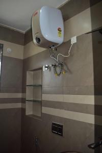 a bathroom with a shower with a hair dryer on the wall at Everfreshhighviewcottage in Ooty