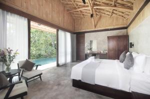 a bedroom with a large bed and a table and chairs at Babakan Hill Villas in Jasri +37 photos