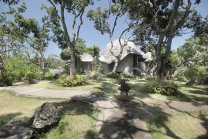 a house with a thatched roof in a garden at Babakan Hill Villas in Jasri