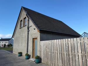 a small church with a wooden fence next to it at The Loft - 96B in Articlave