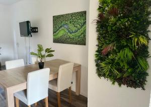 a dining room with a wooden table and white chairs at Green Loft - Haus der Natur in Spiesen-Elversberg