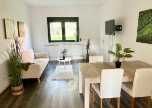 a living room with a table and a couch at Green Loft - Haus der Natur in Spiesen-Elversberg