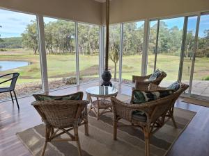 a living room with chairs and a table and windows at Abbivale Farm Cottage in Harewood
