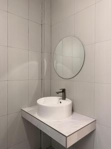 a white bathroom with a sink and a mirror at Wanwichai Room in Ban Lam Ru (1)