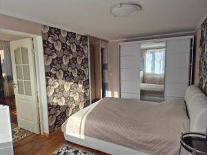 a bedroom with a bed and a couch and a mirror at Mäe Apartment in Tartu