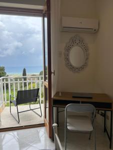 a table and a chair in a room with a balcony at Dream on the blue house 2 in Valderice +5 photos
