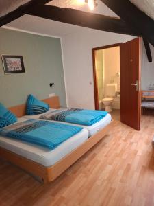 a bedroom with two beds and a bathroom with a toilet at Weingasthaus zum Fährhof in Winningen