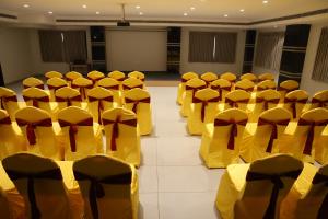 a room with yellow chairs in a room with a stage at Hotel SERENE PRAIA in Visakhapatnam