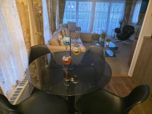 ein Glastisch und Stühle in einem Wohnzimmer in der Unterkunft Seaview in Leysdown-on-Sea