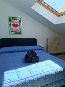 a blue bed with two towels on top of it at Appartamento il Punto Alto in Baveno