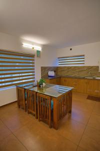 a kitchen with a table and a counter top at Nature Shade Pool Villa in Anachal